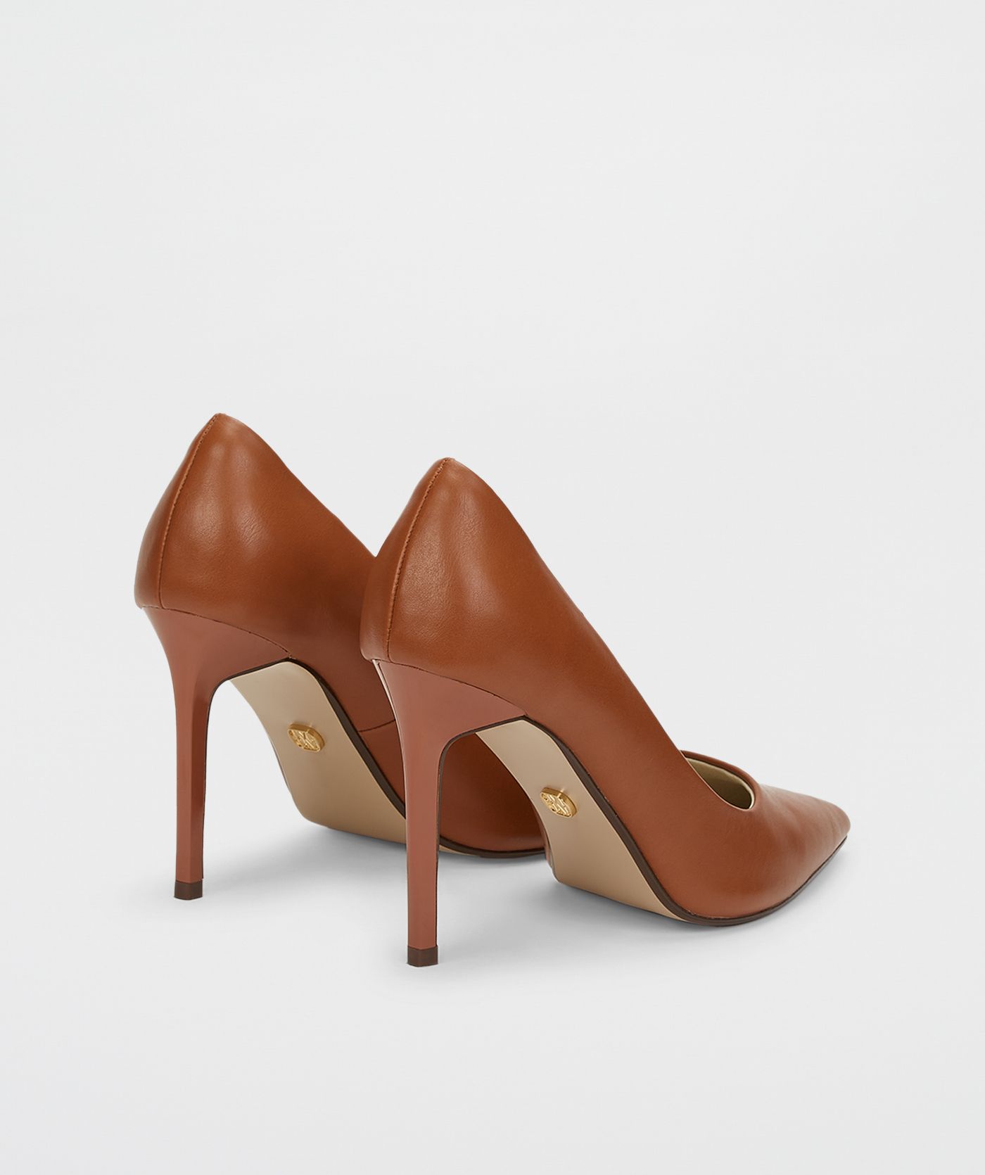 Bruine pumps zonder model, weergegeven op een lichtgrijze achtergrond.