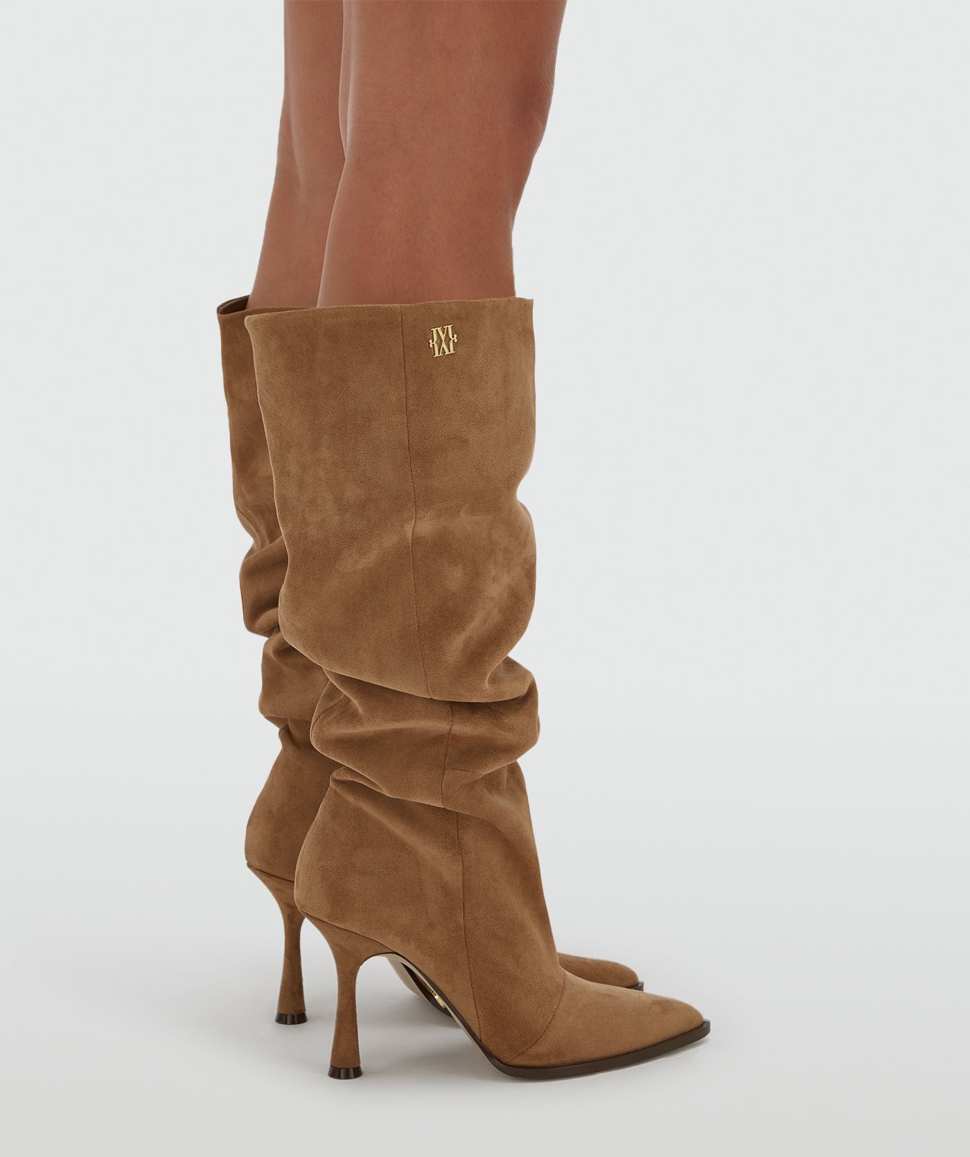 Model draagt hoge suede bruine laarzen.