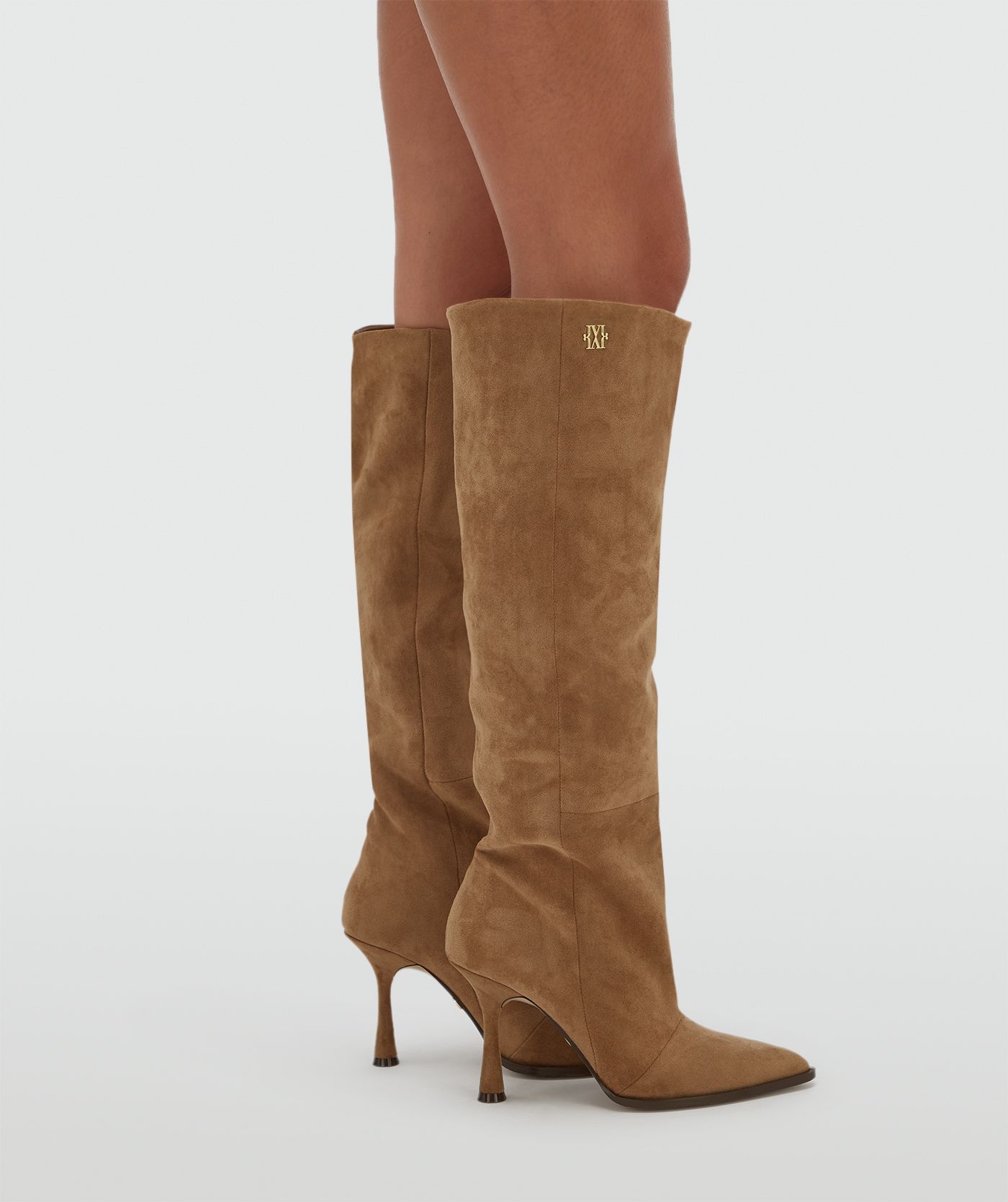 Model draagt hoge suede bruine laarzen.