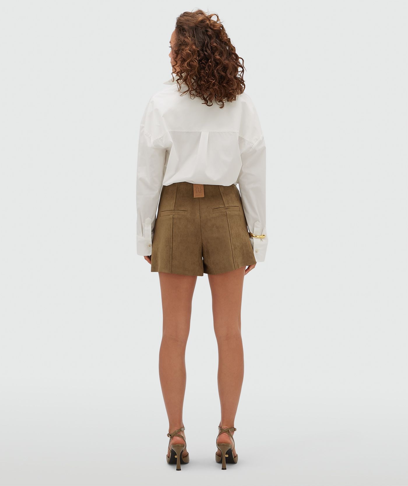 Achteraanzicht van een model in een kort suede broekje.