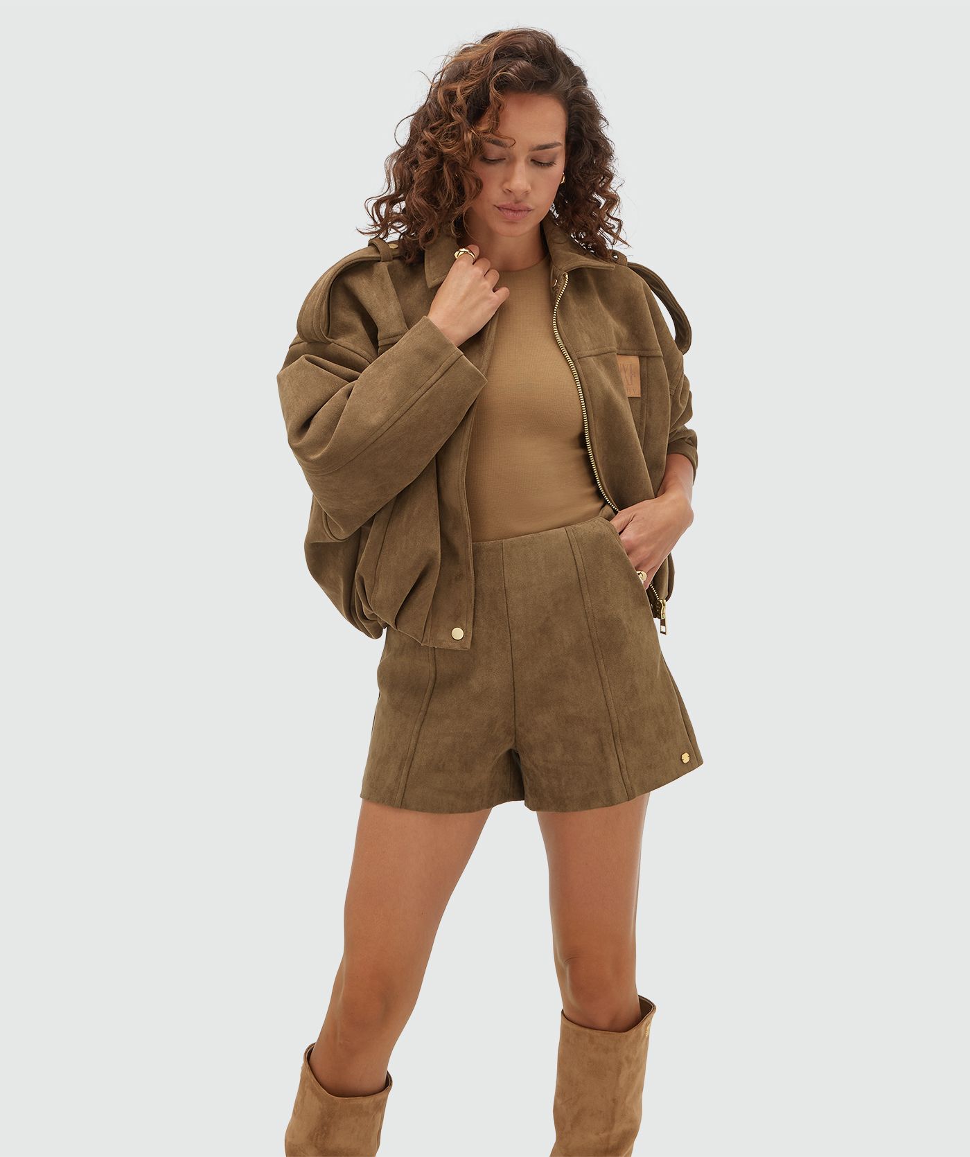 Model draagt een suede bruin kort broekje. 