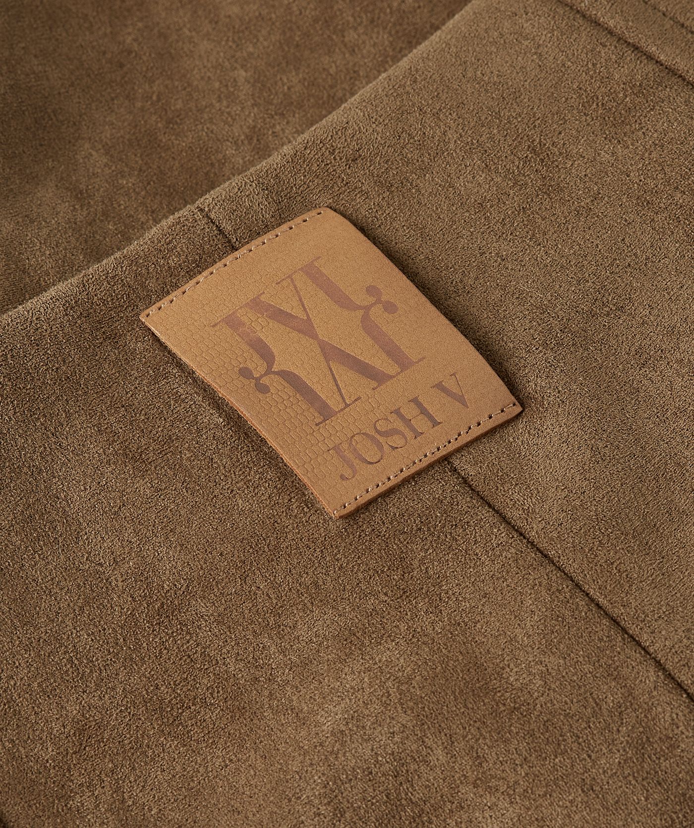Close-up van leer logo op de achterkant met JOSH V-label.