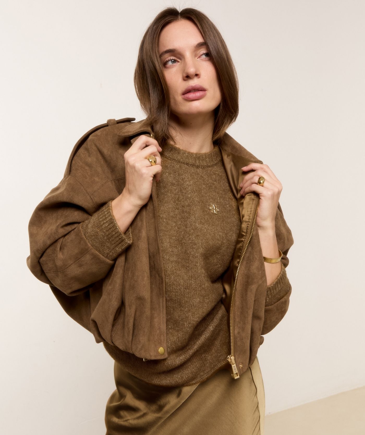 Model draagt het suede look jasje met een trui eronder.