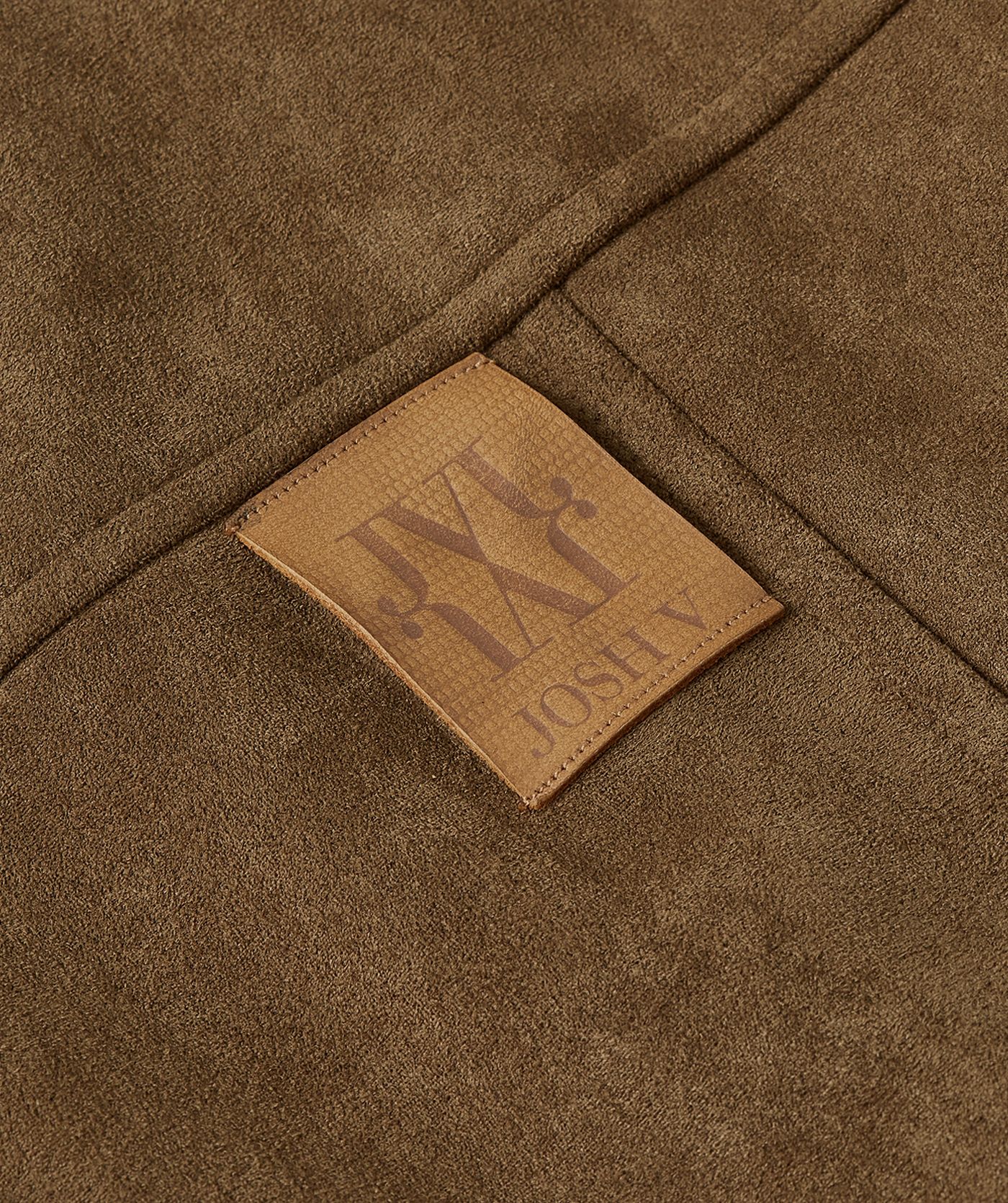 Close-up van leren label op de borst van het suede look jasje.