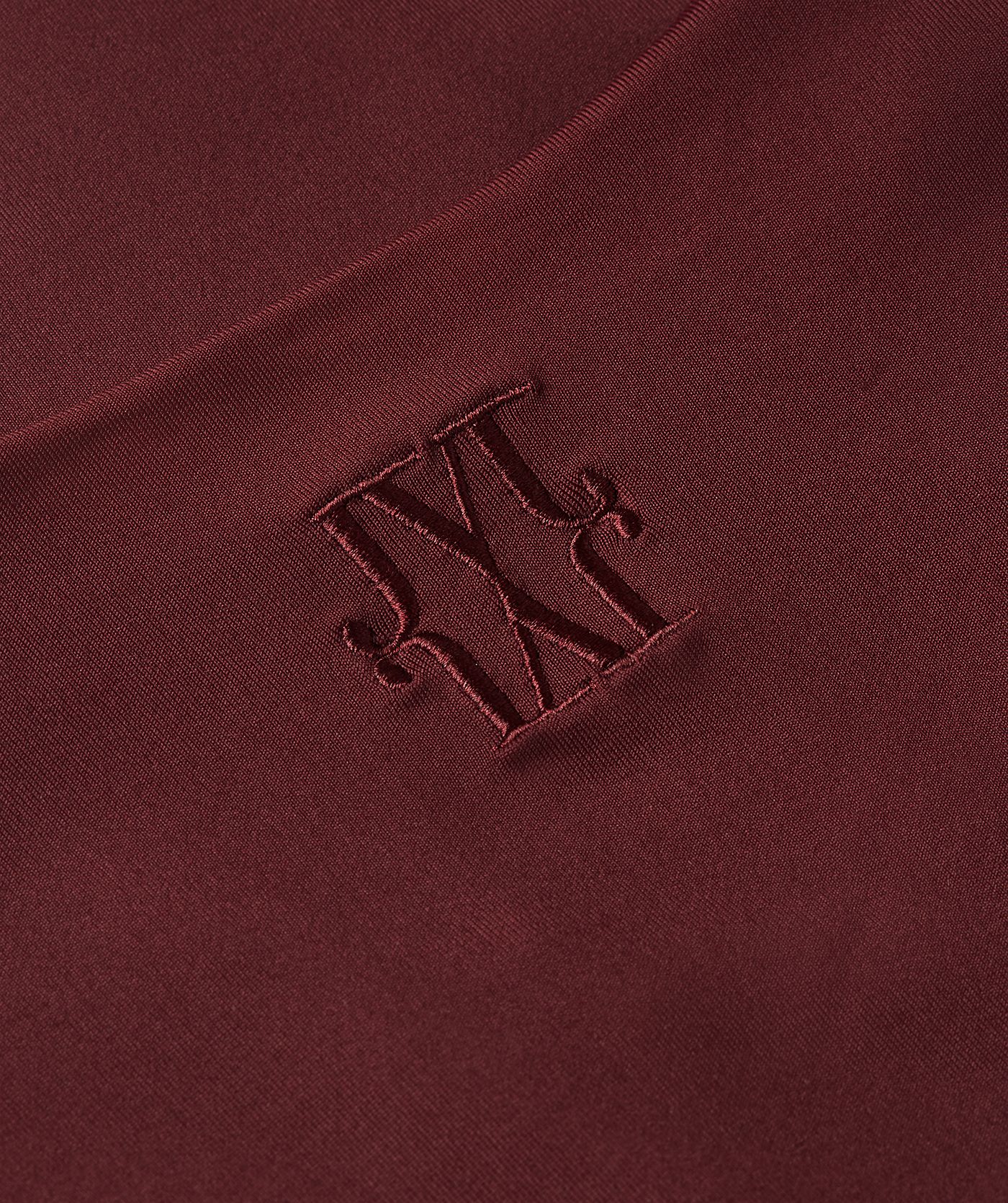 Close-up van JOSH V logo achterin de nek van de donkerrode body.