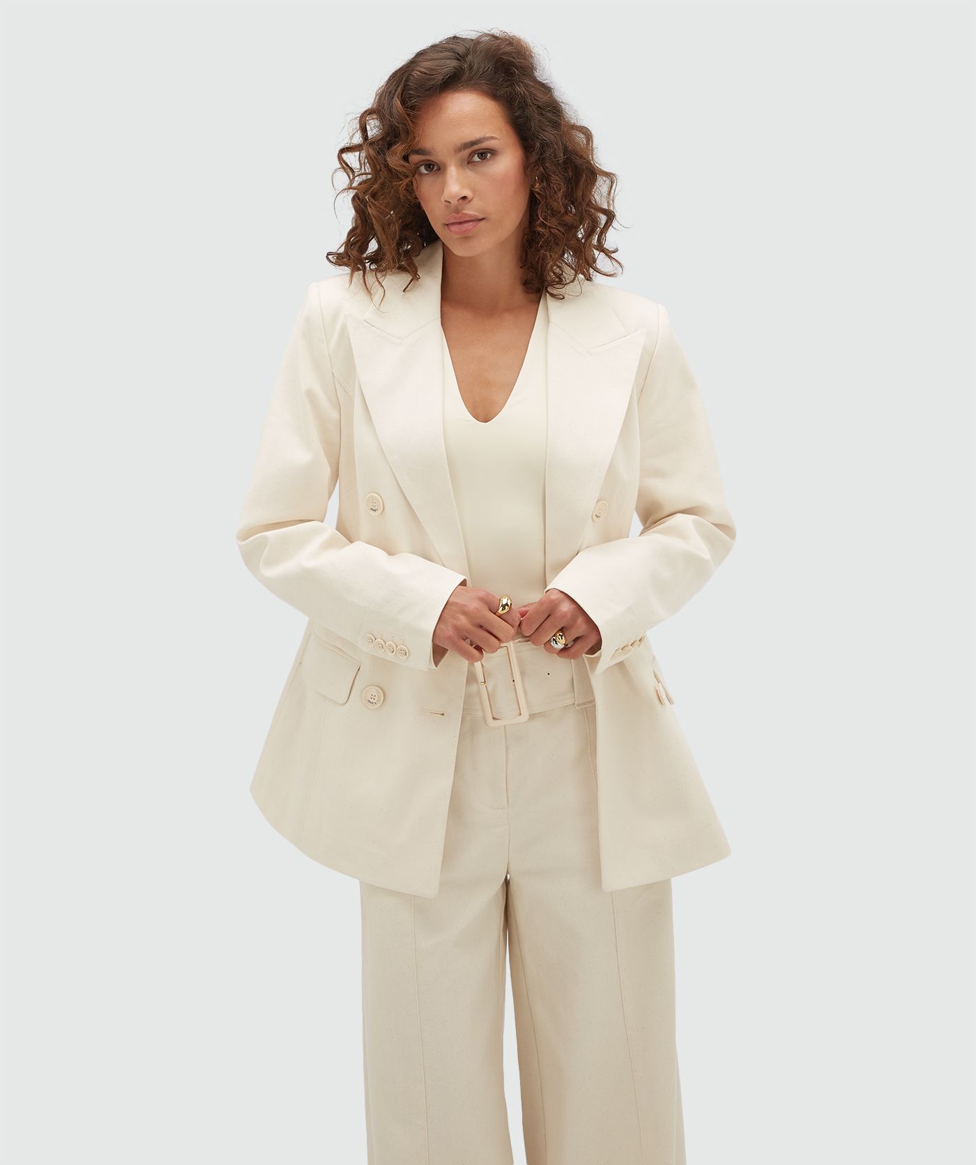 Model draagt een crème blazer met JOSH V-knopen.
