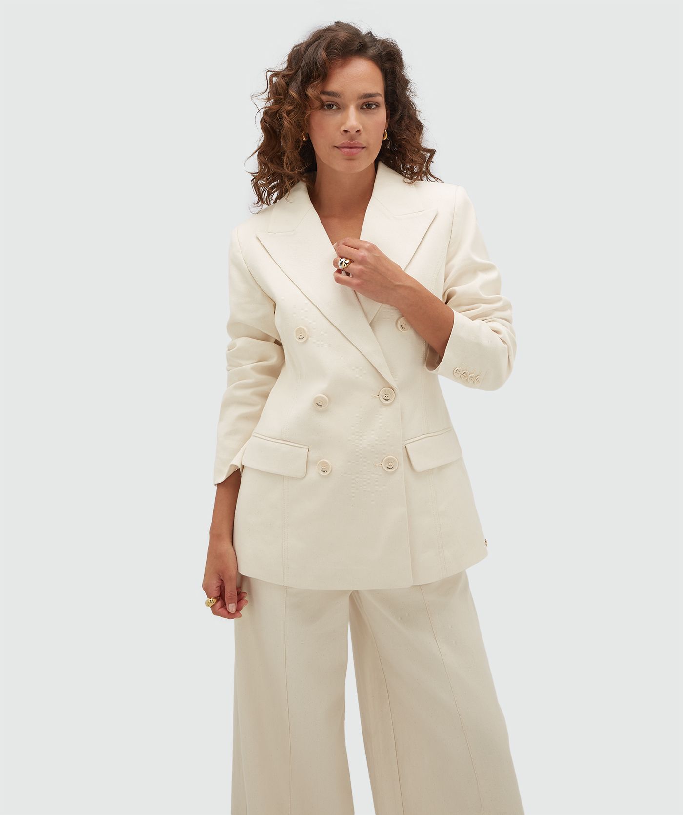 Model draagt een crème blazer met JOSH V-knopen.
