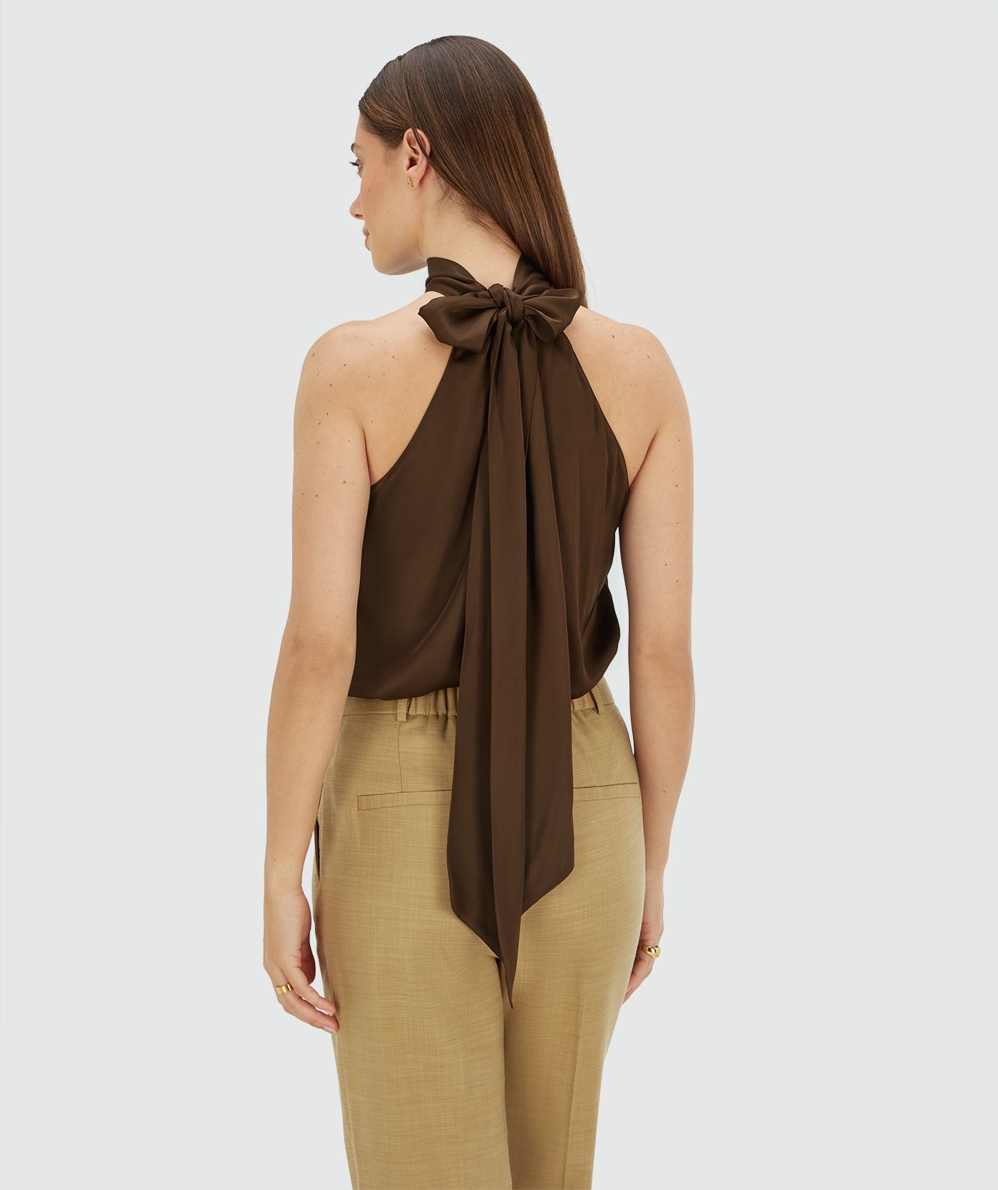 Achterzijde van een model in een loose fit top in satijn look in de kleur Brown