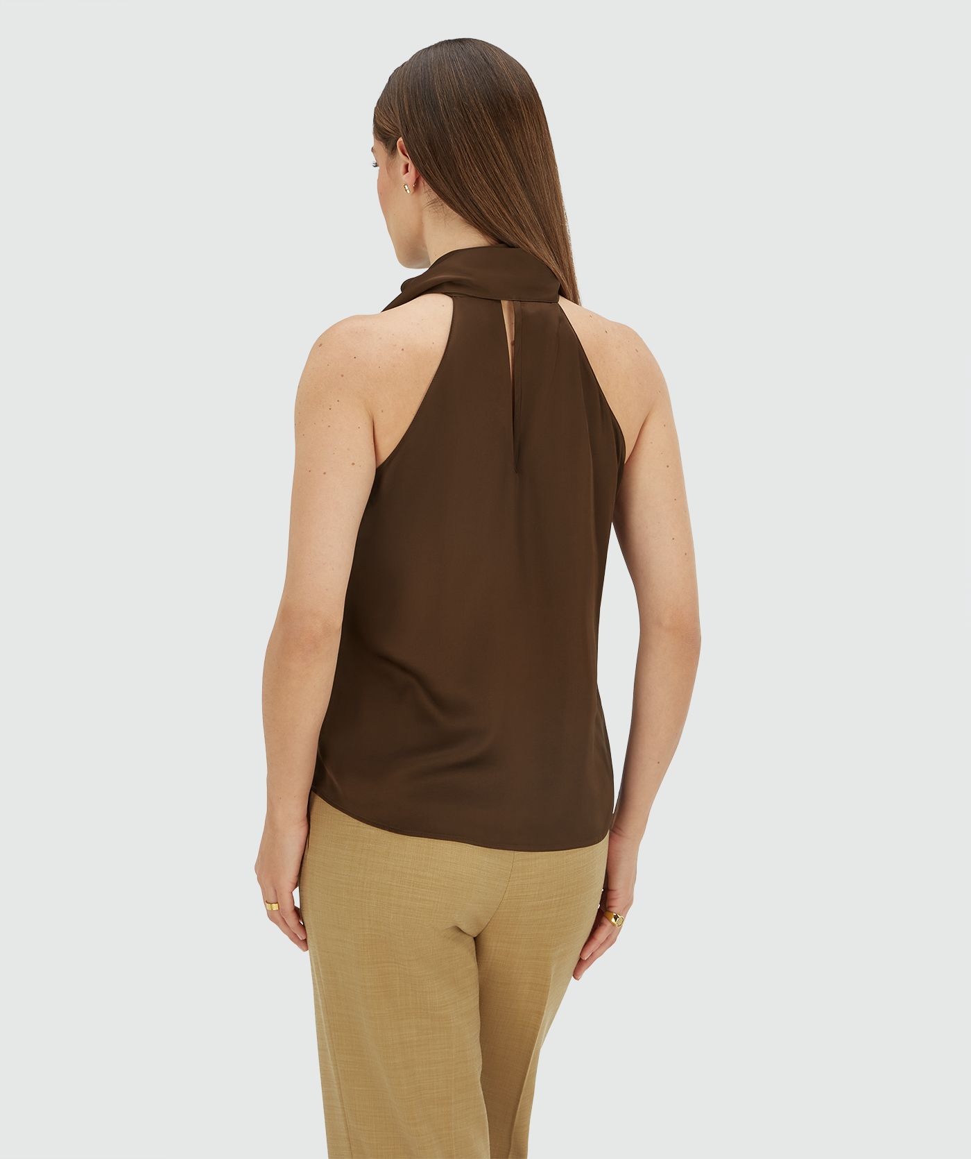 Achterzijde van een model in een loose fit top in satijn look in de kleur Brown