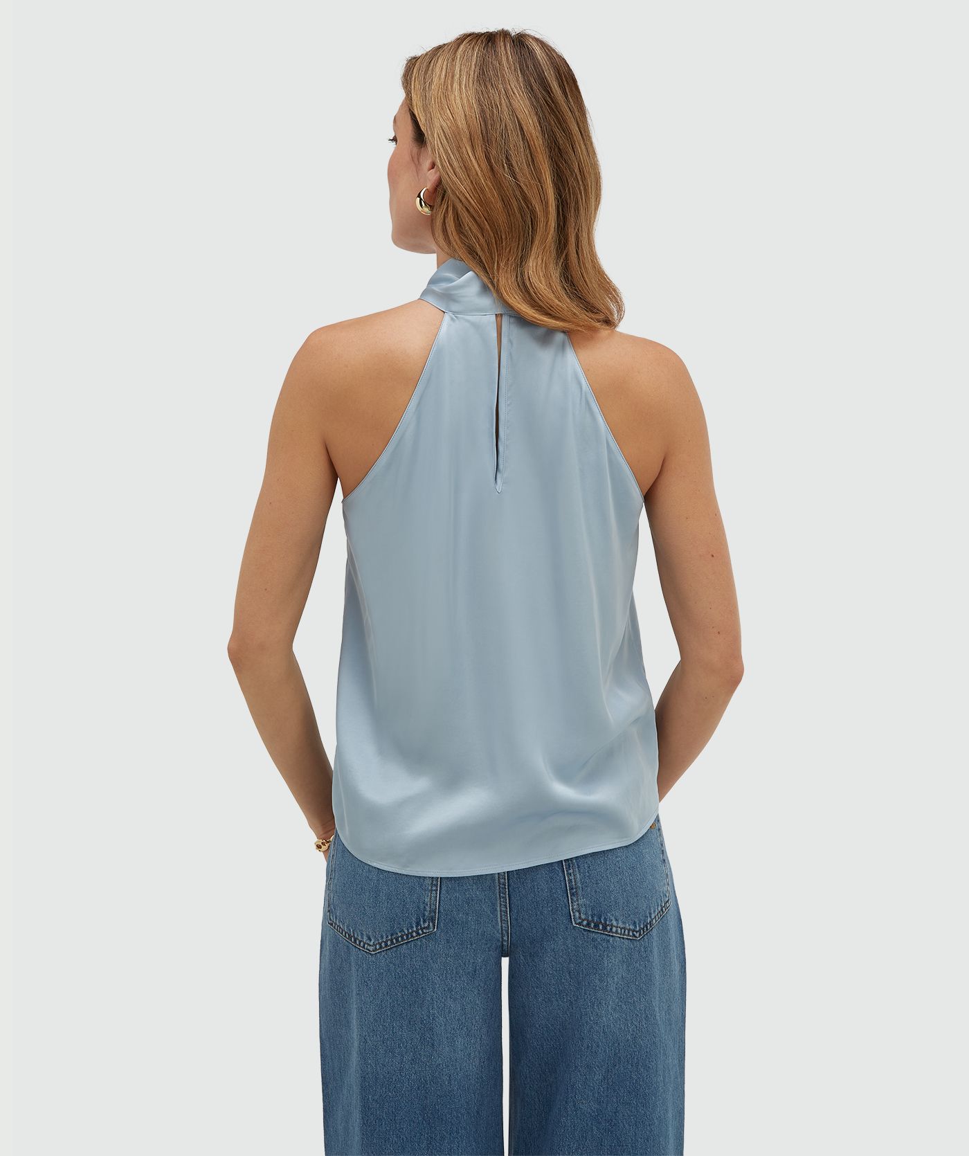Achteraanzicht van een model in een loose fit top in satijn look in de kleur Fresh Blue