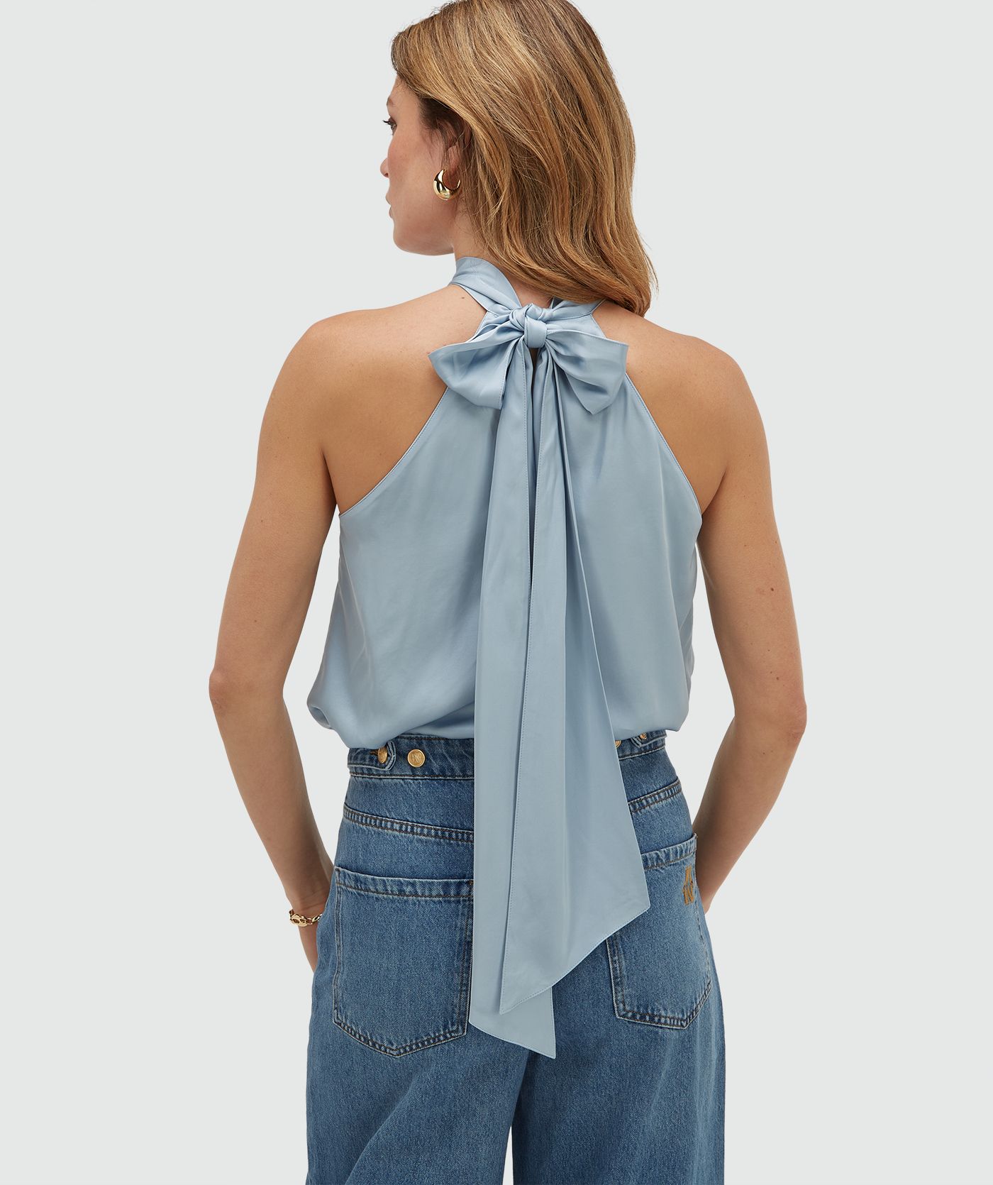 Achteraanzicht van een model in een loose fit top in satijn look in de kleur Fresh Blue