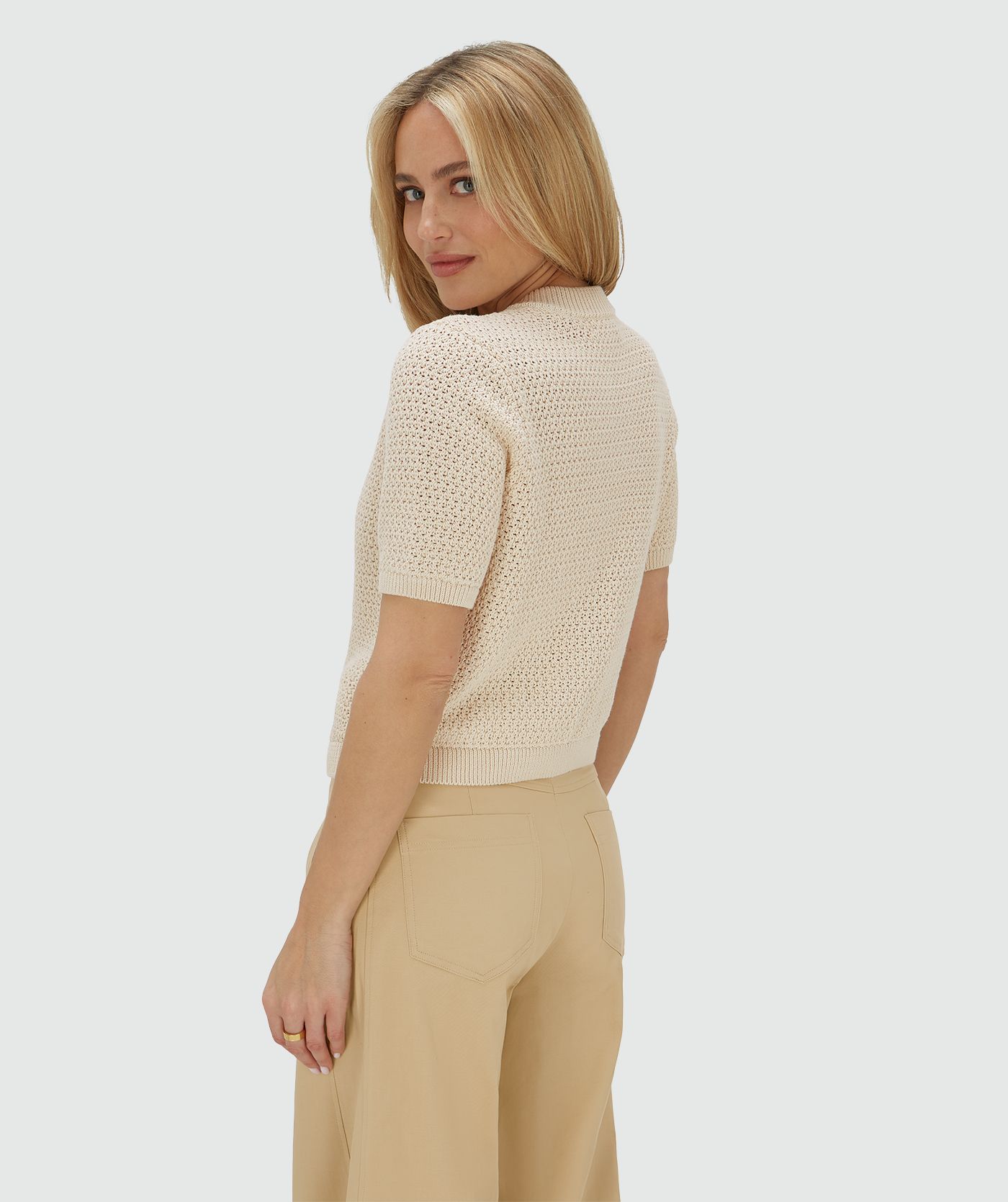 Zijaanzicht van het model in een ecrukleurig vest met een regular fit