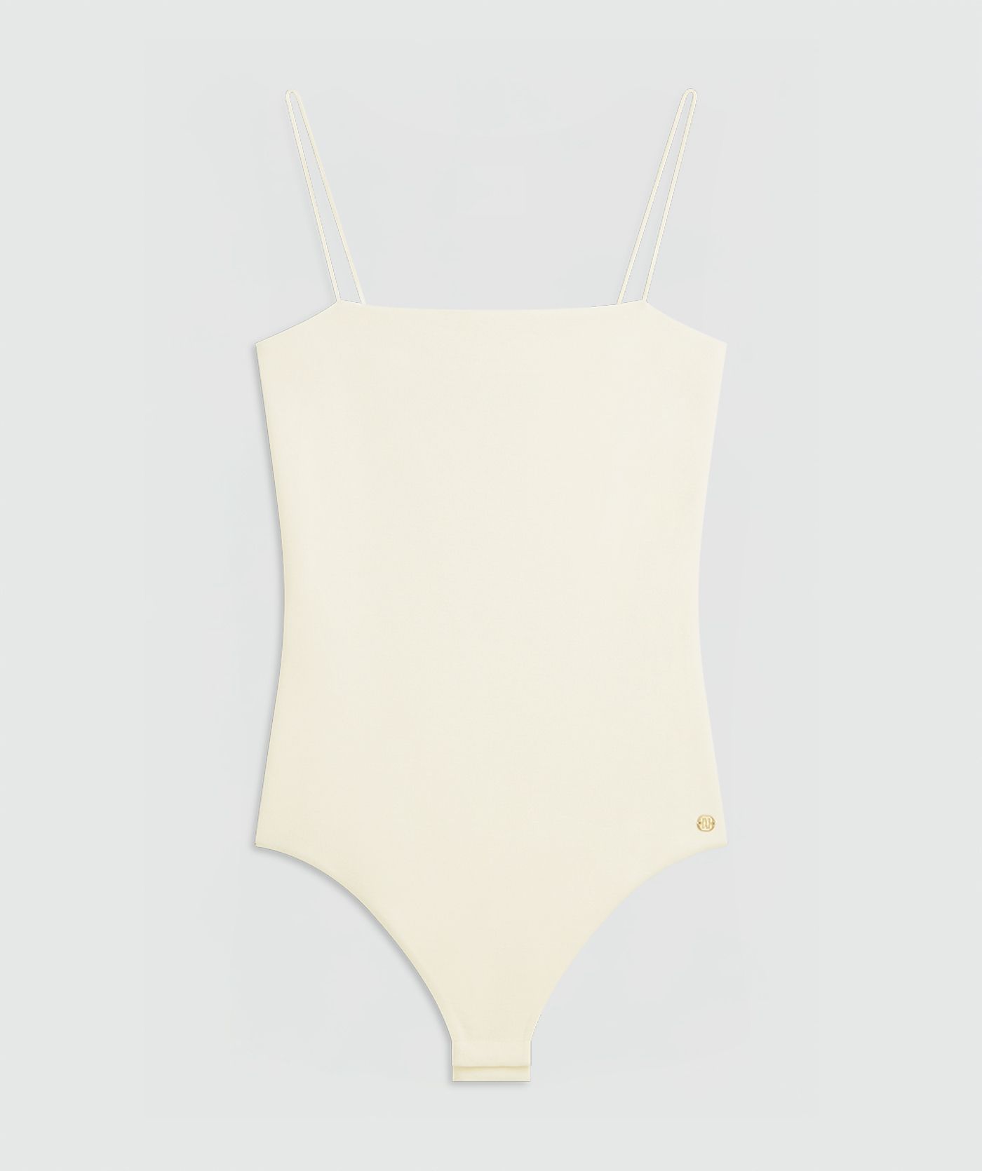 Creme white body met dunne bandjes zonder model, weergegeven op een lichtgrijze achtergrond.