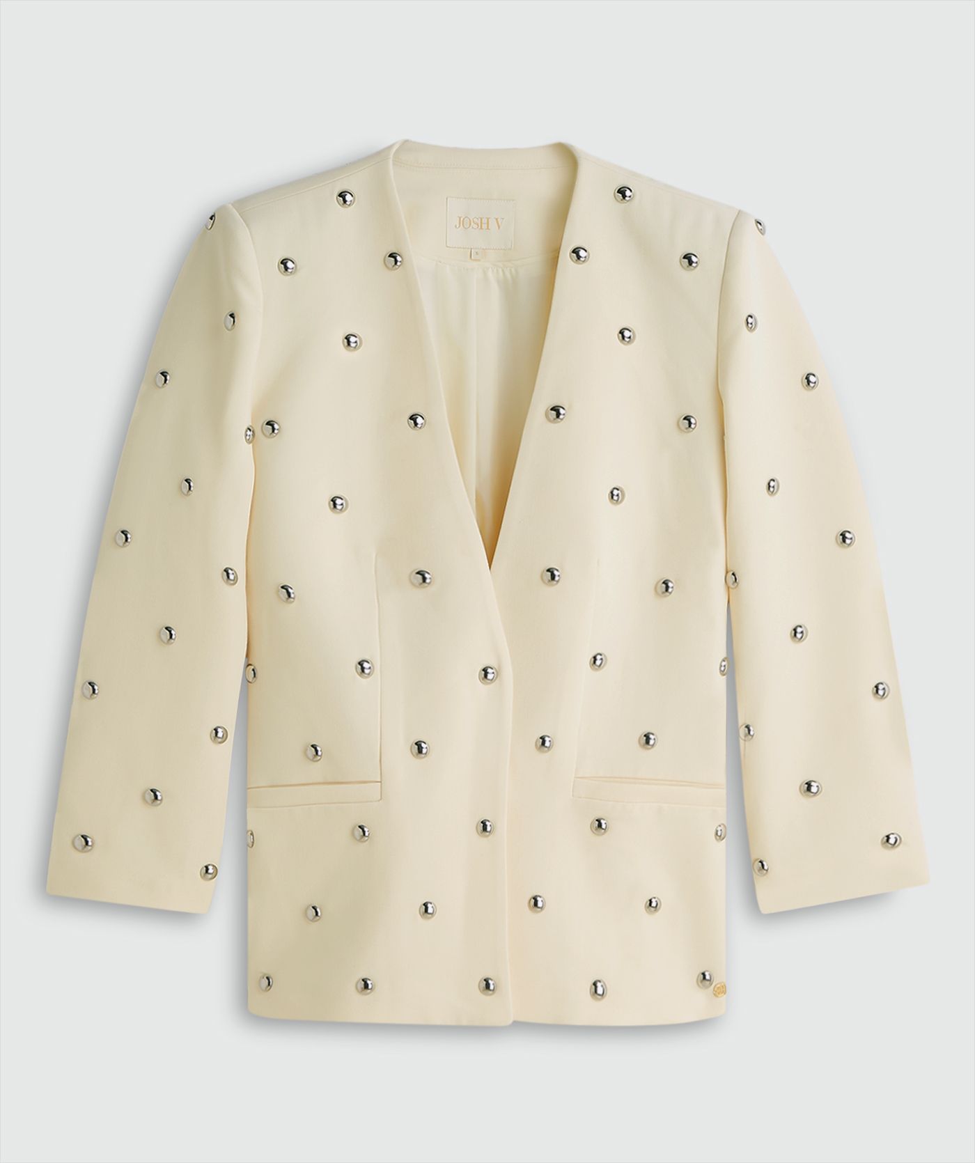 Lichtgele blazer met zilveren studs zonder model, weergegeven op een lichtgrijze achtergrond
