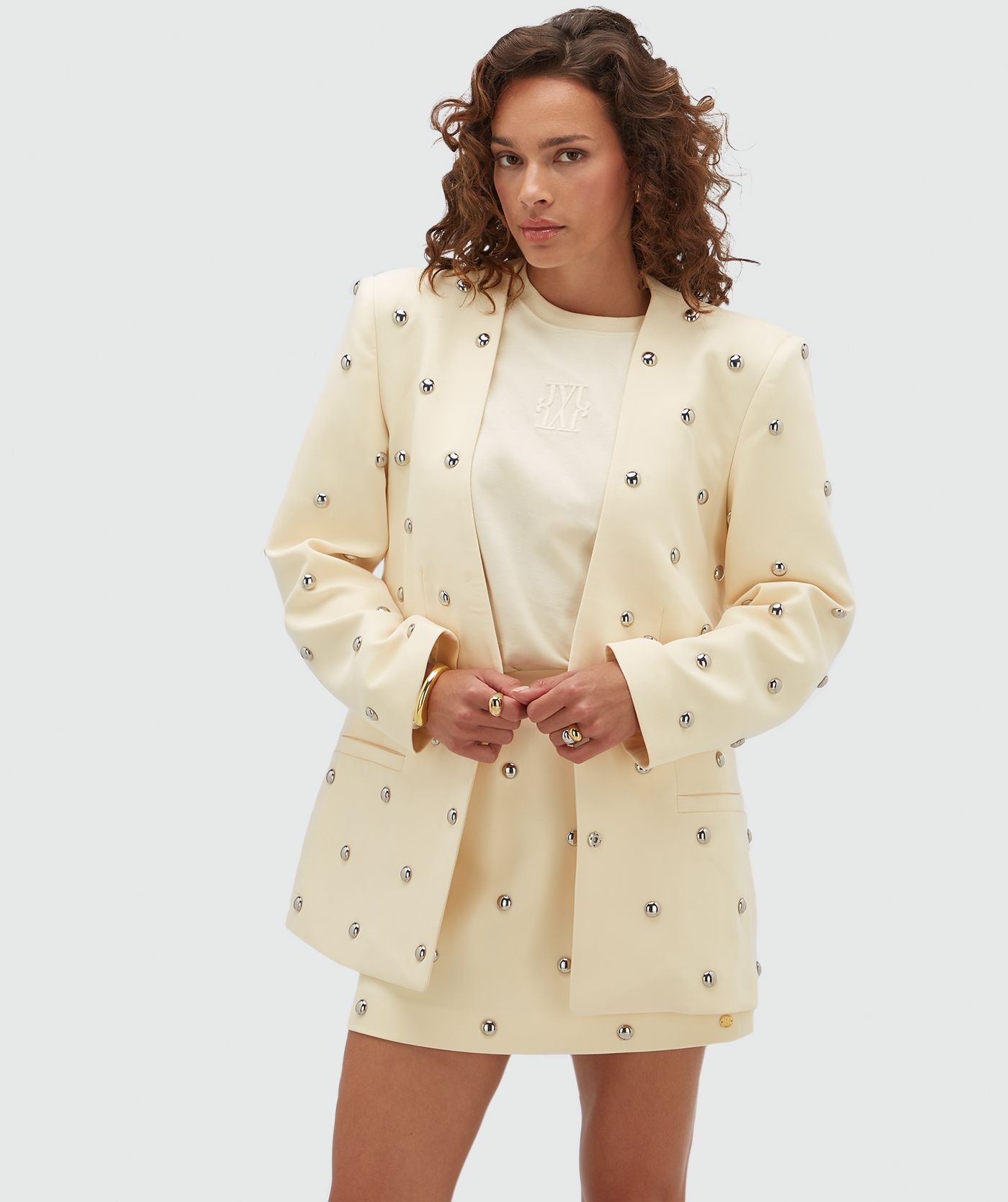 Model draagt een lichtgeel rokje met zilveren studs.