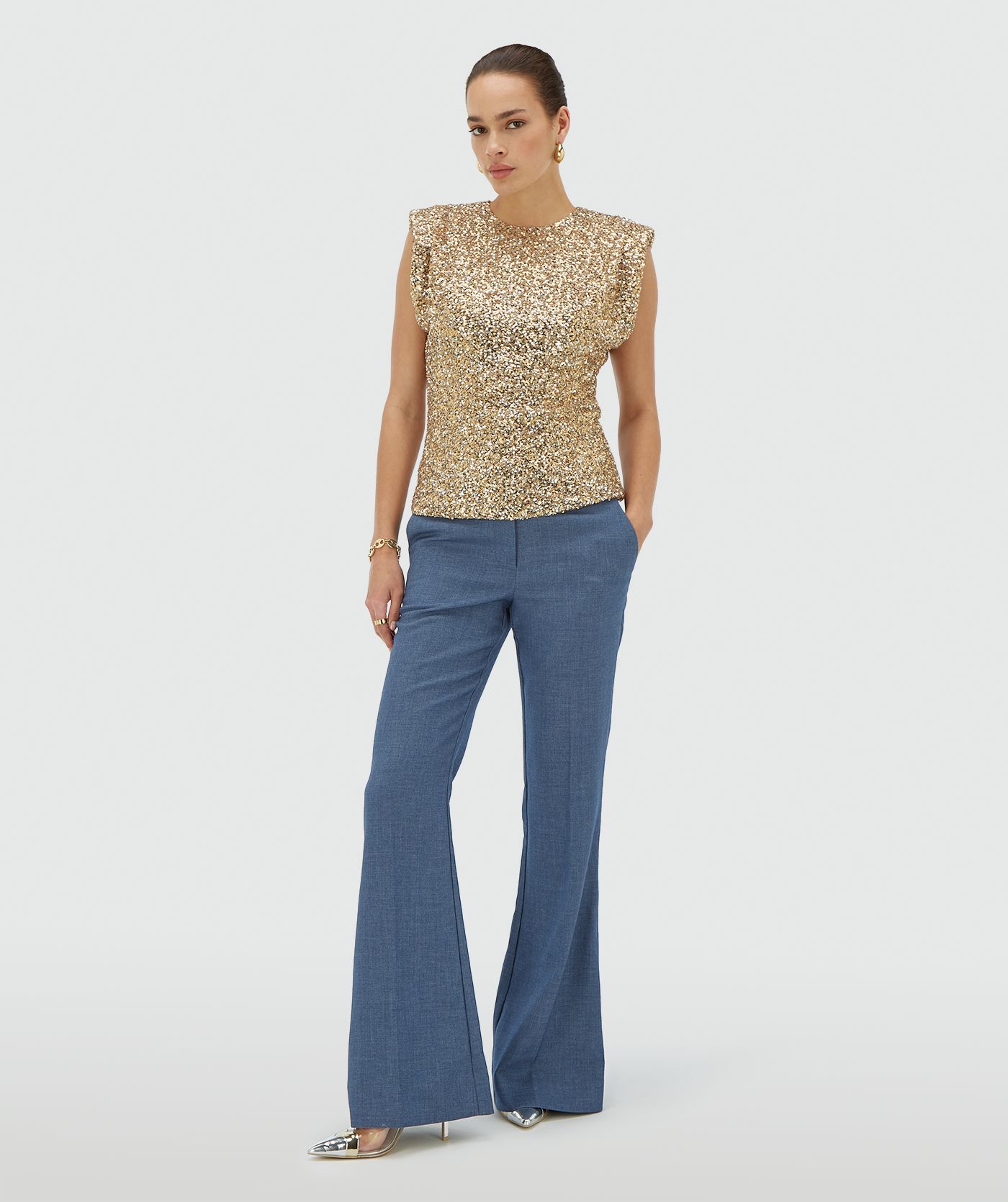 Model draagt een mouwloze goud zilver pailletten top met schoudervulling - JOSH V